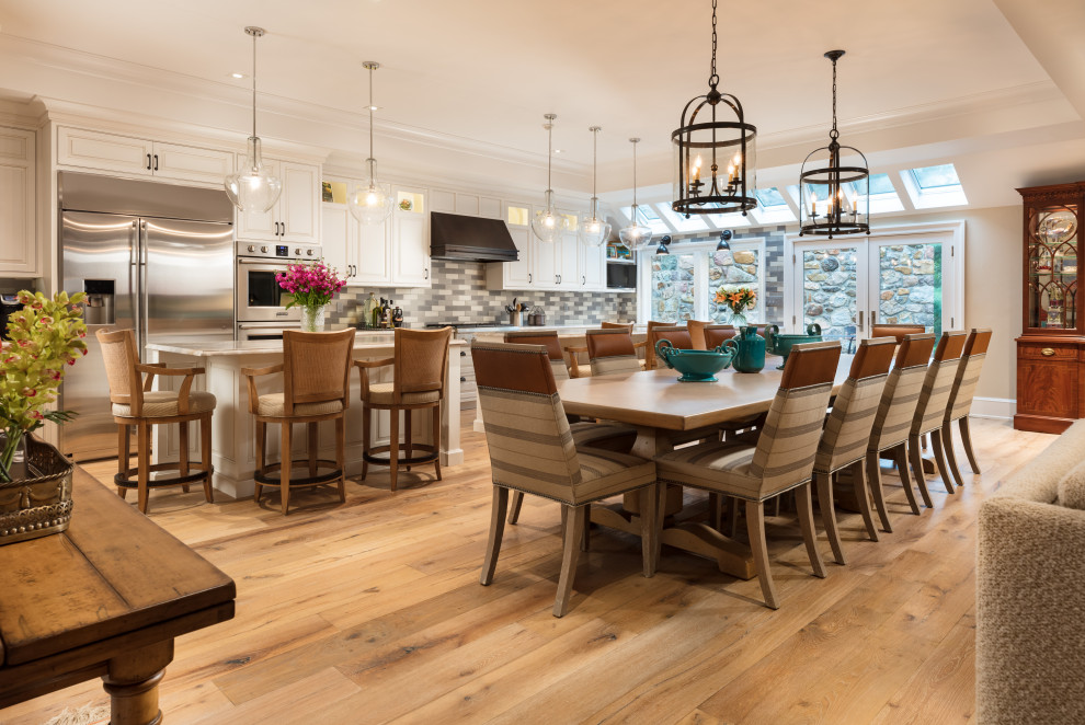 Foto di una sala da pranzo aperta verso il soggiorno tradizionale con pareti beige, pavimento in legno massello medio, pavimento marrone e soffitto ribassato