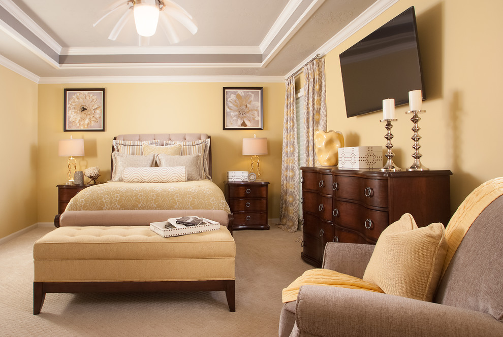 Photo of a mid-sized transitional master bedroom in Atlanta with yellow walls and carpet.