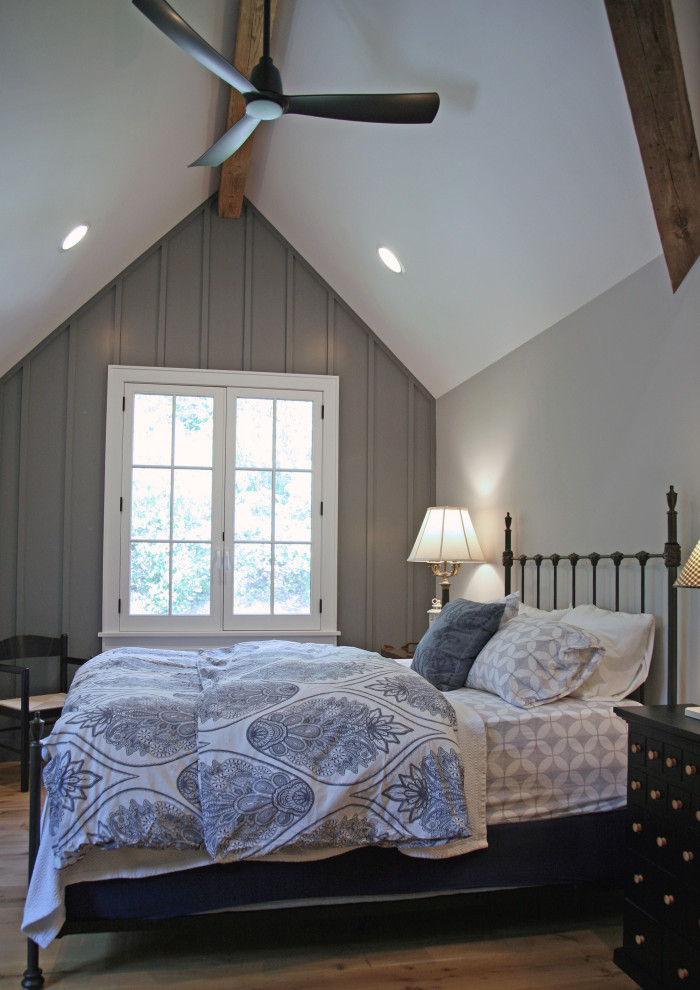 Пример оригинального дизайна: гостевая спальня среднего размера, (комната для гостей) в стиле кантри с серыми стенами, паркетным полом среднего тона, коричневым полом, сводчатым потолком и деревянными стенами