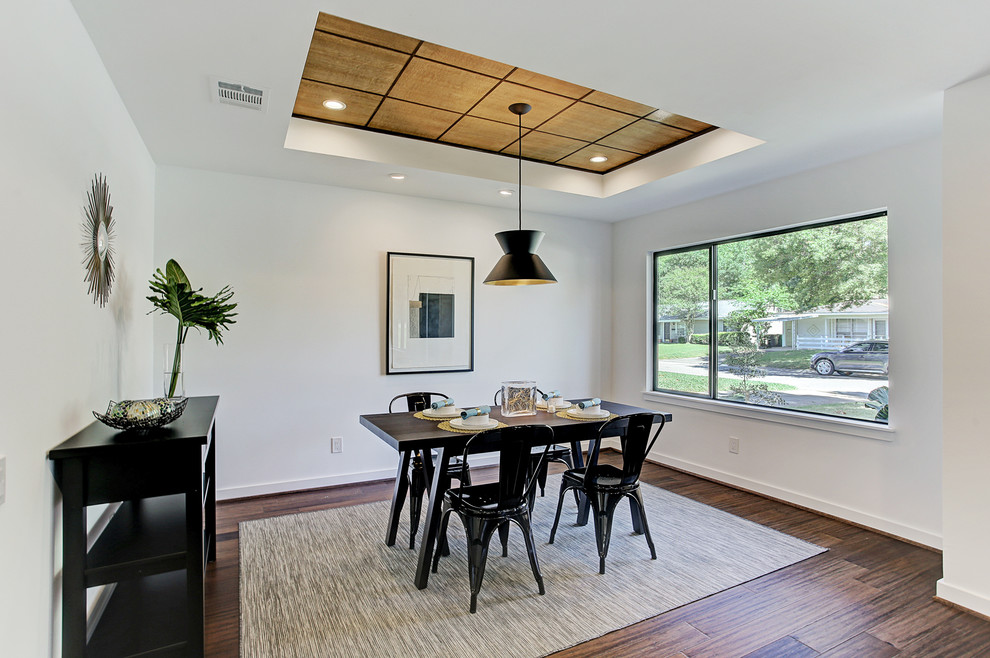 Midcentury dining room in Houston with white walls, bamboo floors and brown floor.