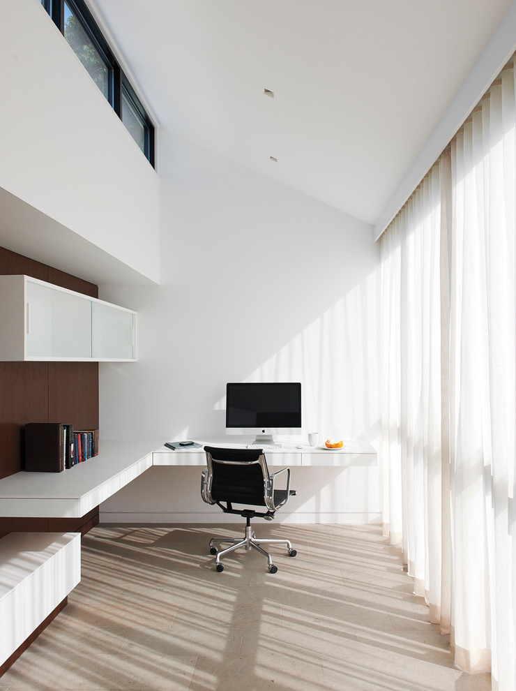 Photo of a modern study room in New York with white walls, a built-in desk and no fireplace.