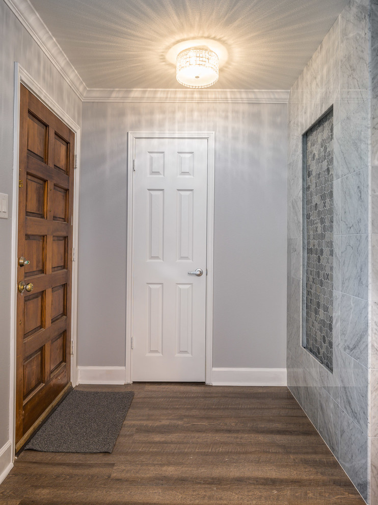 Photo of a mid-sized modern front door in Houston with grey walls, laminate floors, a single front door, a medium wood front door and brown floor.
