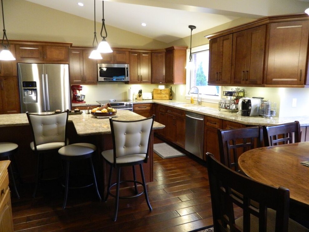 Inspiration for a transitional medium tone wood floor eat-in kitchen remodel in Toronto with an undermount sink, recessed-panel cabinets, quartz countertops, stainless steel appliances and an island
