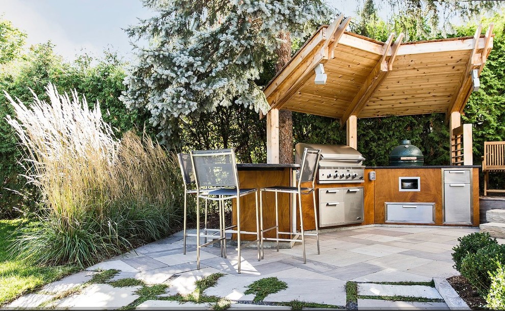 This is an example of a mid-sized modern front yard patio in Ottawa with natural stone pavers, an outdoor kitchen and a gazebo/cabana.