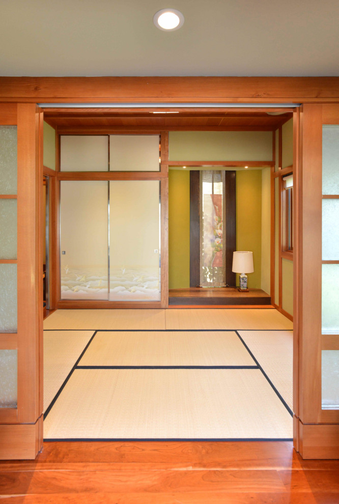 Inspiration for a mid-sized asian guest bedroom in Austin with tatami floors, beige floor, green walls and wood.