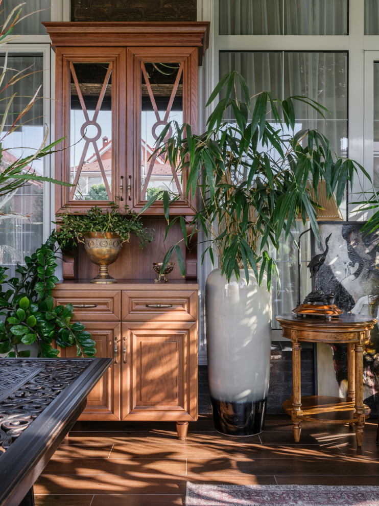 На фото: большая веранда на заднем дворе в классическом стиле с вертикальным садом, мощением тротуарной плиткой, навесом и стеклянными перилами
