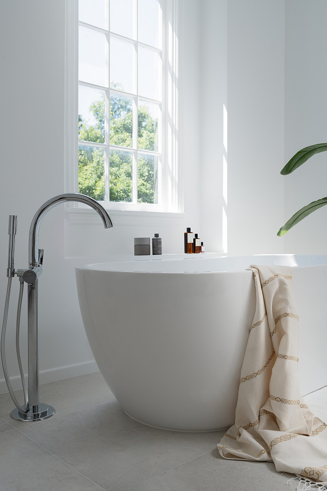Photo of a large contemporary bathroom with flat-panel cabinets, white cabinets, a freestanding bath, a corner shower, a wall mounted toilet, white tiles, ceramic tiles, white walls, ceramic flooring, a pedestal sink, laminate worktops, grey floors, an open shower, white worktops, a laundry area, double sinks, a floating vanity unit and panelled walls.