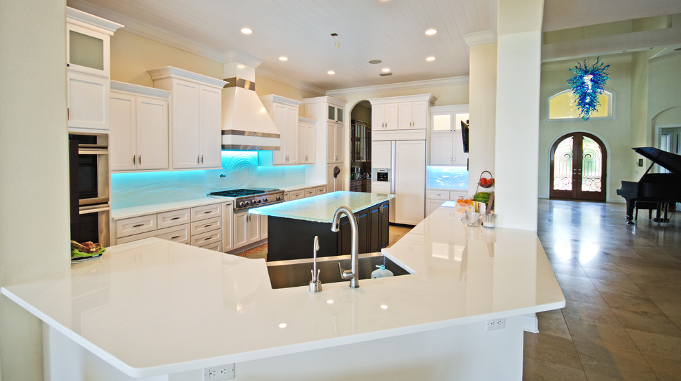 Inspiration for a large contemporary l-shaped open plan kitchen in Tampa with a farmhouse sink, shaker cabinets, white cabinets, glass benchtops, multi-coloured splashback, glass sheet splashback and with island.