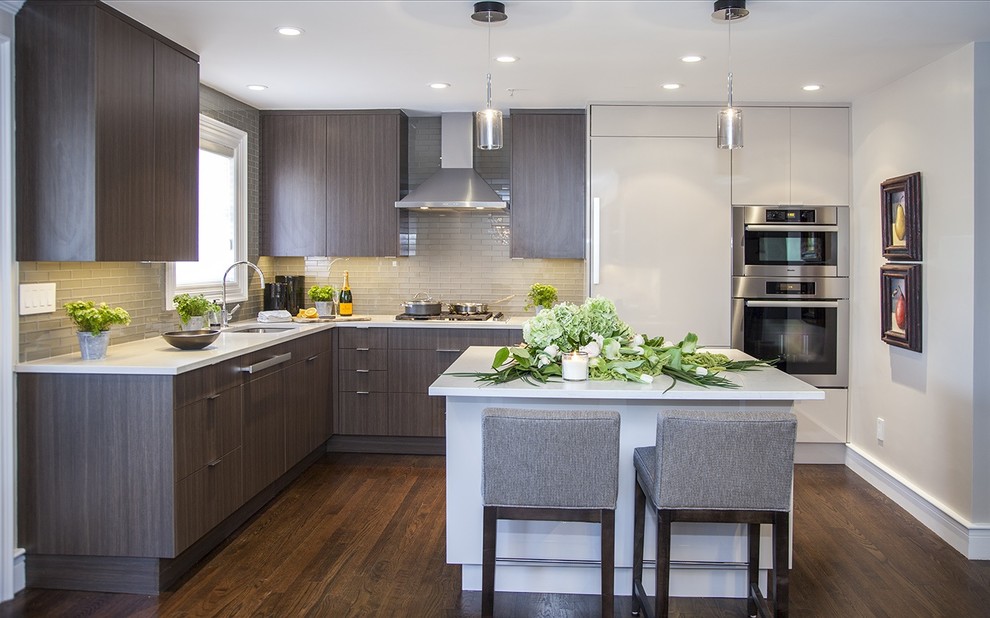 Inspiration for a contemporary l-shaped kitchen in Boston with an undermount sink, flat-panel cabinets, dark wood cabinets, grey splashback, glass tile splashback, stainless steel appliances, dark hardwood floors and with island.