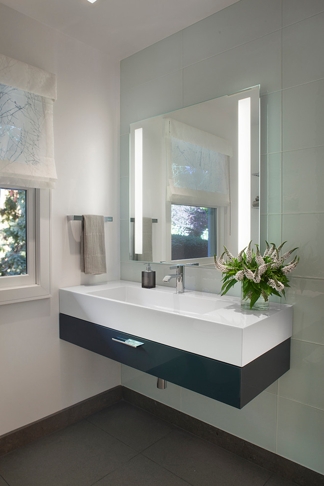 Photo of a mid-sized transitional 3/4 bathroom in San Francisco with flat-panel cabinets, black cabinets, a corner shower, blue tile, glass tile, blue walls, ceramic floors, an integrated sink and solid surface benchtops.