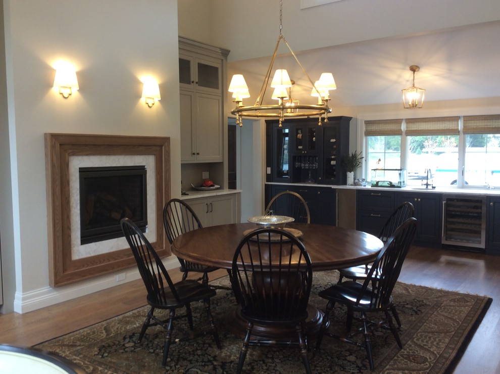 Example of a mid-sized transitional medium tone wood floor eat-in kitchen design in Chicago with an undermount sink, stainless steel appliances, shaker cabinets, blue cabinets and no island