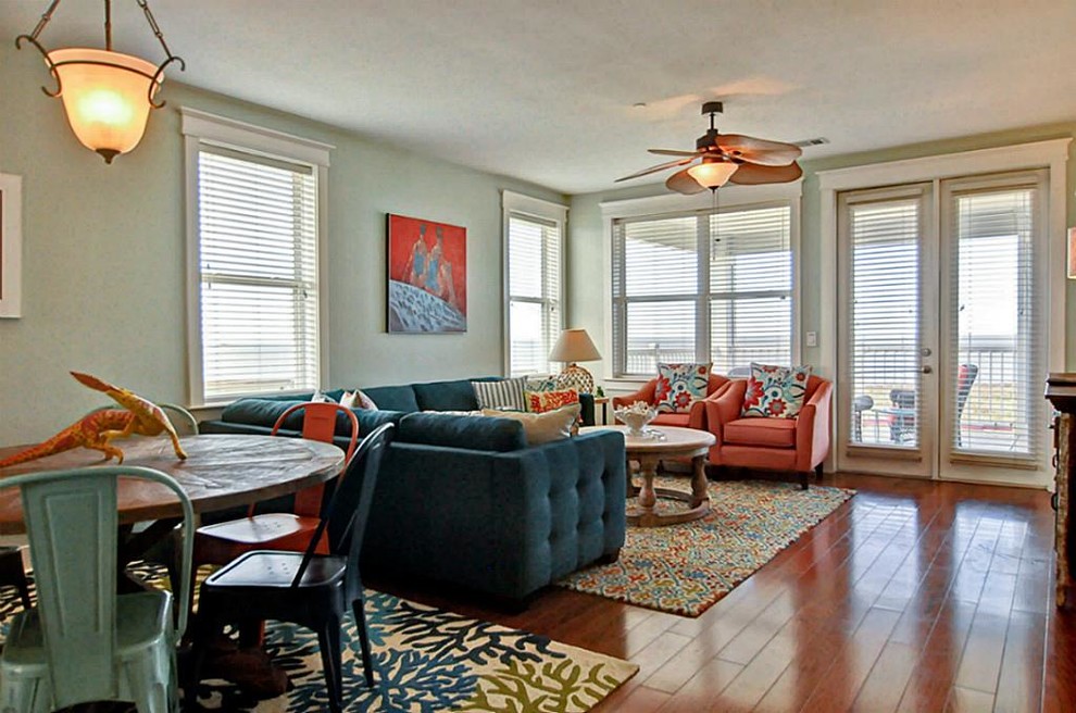 Photo of a mid-sized beach style open concept living room in Houston with medium hardwood floors, brown floor, no fireplace, grey walls and no tv.