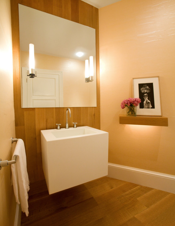 Small modern powder room in Boston with a one-piece toilet, yellow walls and light hardwood floors.