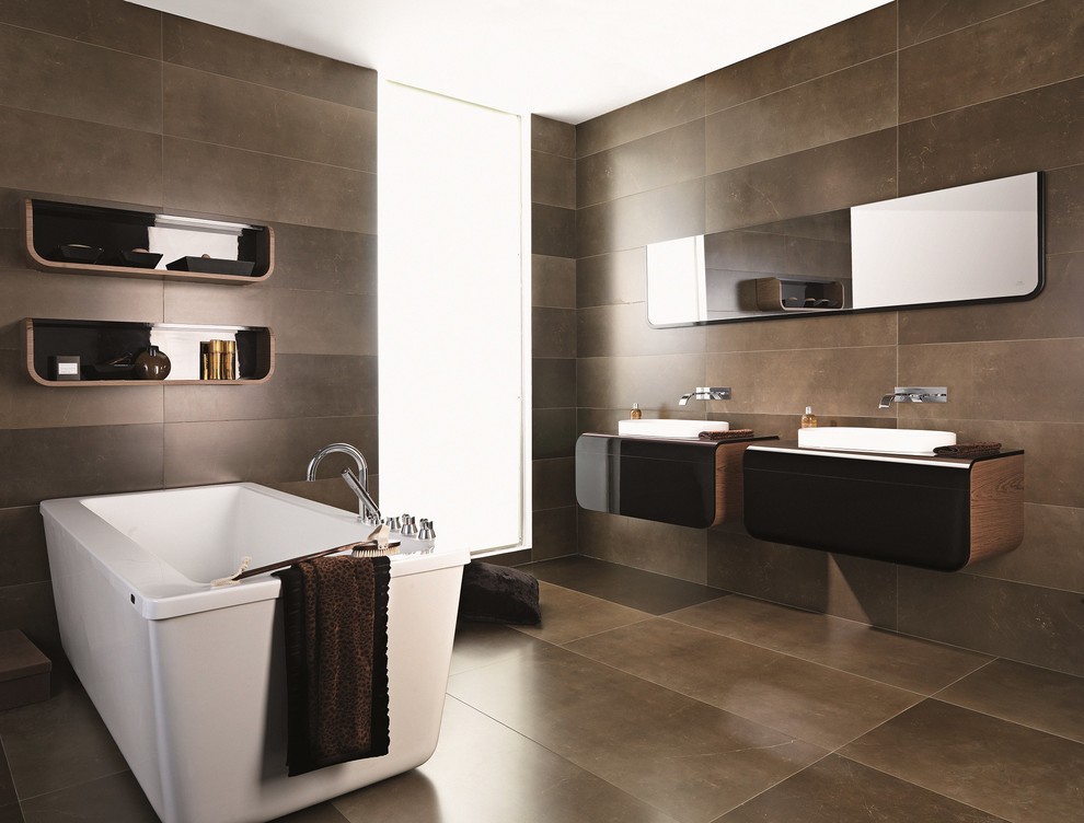 Photo of a large modern master bathroom in New Orleans with flat-panel cabinets, medium wood cabinets, a freestanding tub, brown tile, porcelain tile, brown walls, porcelain floors, a vessel sink and glass benchtops.