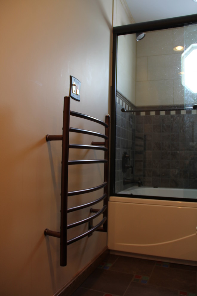 Example of a transitional brown tile and porcelain tile porcelain tile tub/shower combo design in Columbus with a vessel sink, an undermount tub, a two-piece toilet, raised-panel cabinets, medium tone wood cabinets, granite countertops and beige walls