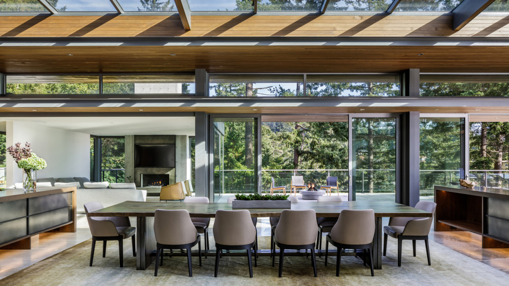 Offenes, Geräumiges Modernes Esszimmer mit Betonboden, Kamin, Kaminumrandung aus Beton und freigelegten Dachbalken in Vancouver