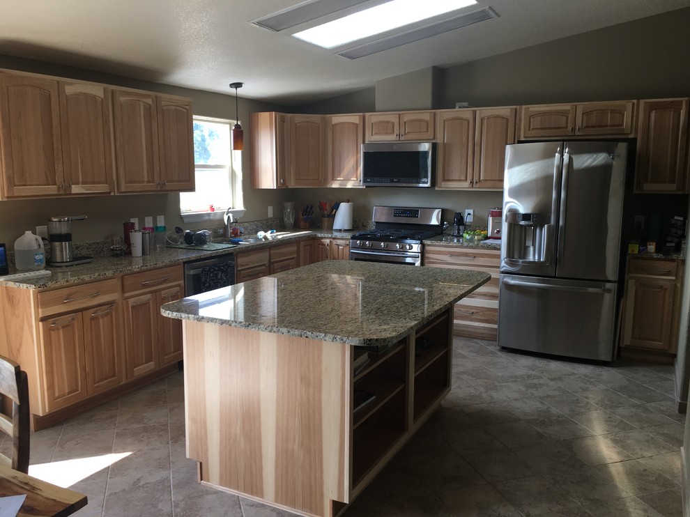 Eat-in kitchen - large rustic l-shaped porcelain tile and beige floor eat-in kitchen idea in Denver with an undermount sink, raised-panel cabinets, brown cabinets, granite countertops, stainless steel appliances, an island and beige countertops