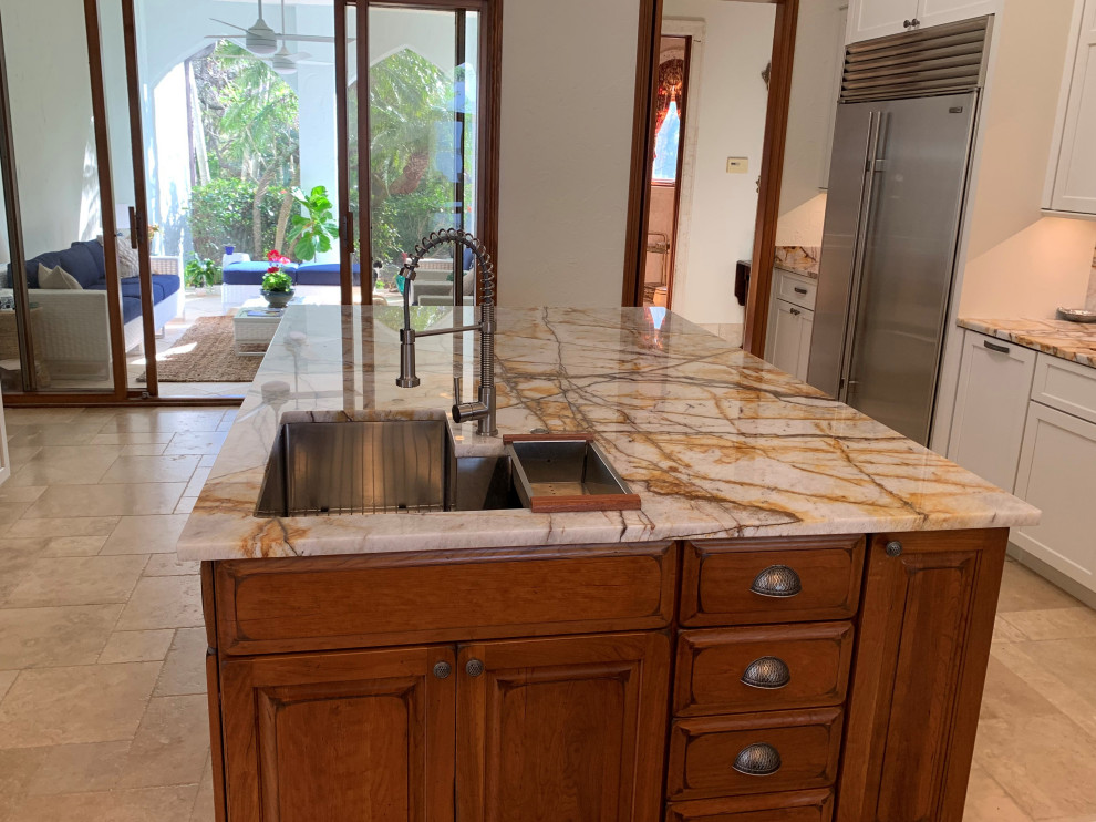 Example of a transitional beige floor eat-in kitchen design with a single-bowl sink, raised-panel cabinets, distressed cabinets, stainless steel appliances, two islands and multicolored countertops