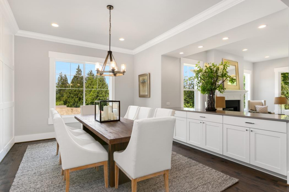 Large arts and crafts open plan dining in Seattle with grey walls, dark hardwood floors, a standard fireplace, a wood fireplace surround and brown floor.