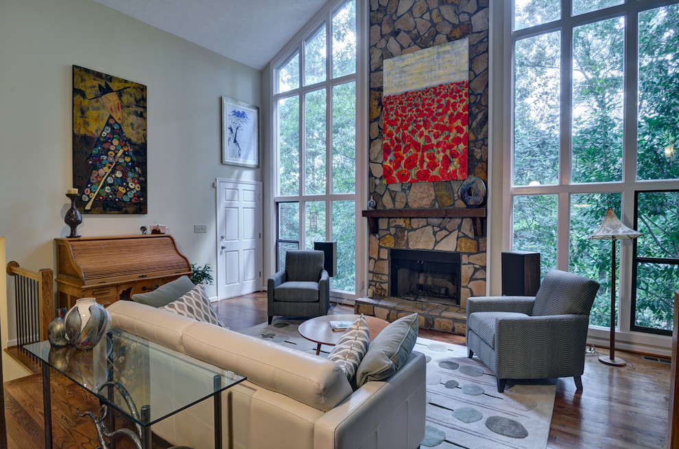 Photo of an eclectic living room in Atlanta with a standard fireplace and a stone fireplace surround.