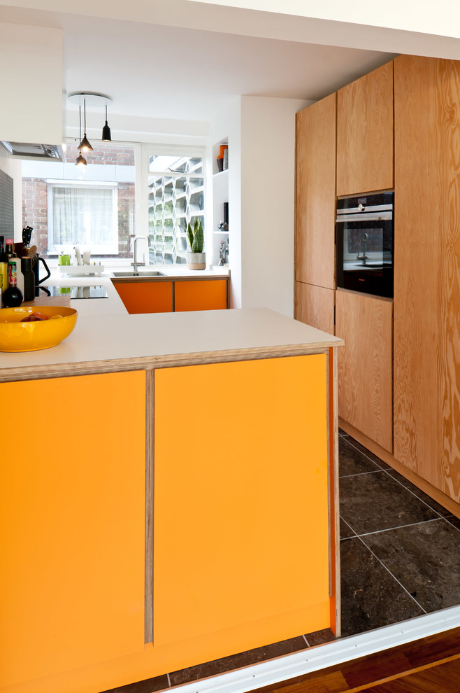 Photo of a contemporary separate kitchen in London with flat-panel cabinets and no island.