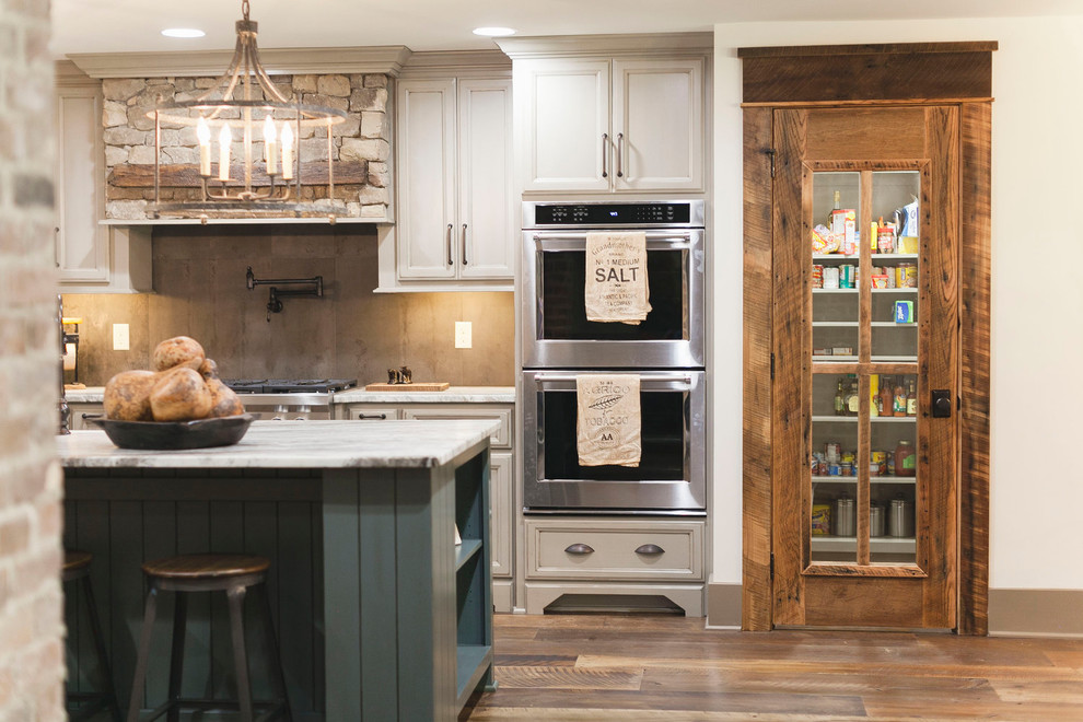 Inspiration for a rustic u-shaped medium tone wood floor and brown floor eat-in kitchen remodel with recessed-panel cabinets, white cabinets, marble countertops, an island, a farmhouse sink, gray backsplash, cement tile backsplash, stainless steel appliances and gray countertops