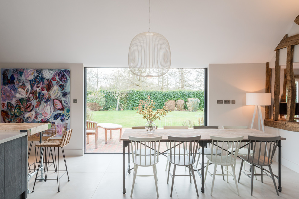 Photo of a mid-sized country open plan dining in Other with white walls, limestone floors and white floor.