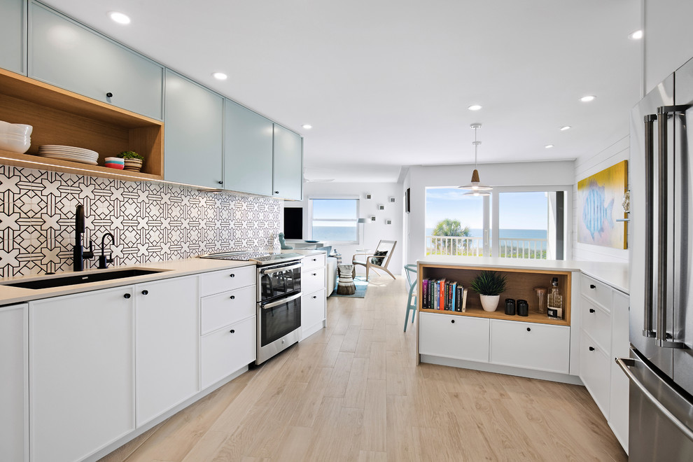 Small beach style eat-in kitchen in Tampa with an undermount sink, shaker cabinets, white cabinets, quartzite benchtops, ceramic splashback, stainless steel appliances, ceramic floors, a peninsula and beige floor.