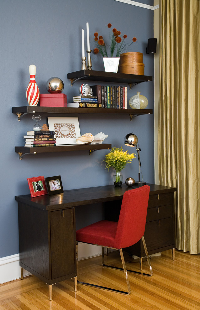 This is an example of a small contemporary home office in San Francisco with blue walls, medium hardwood floors, a freestanding desk, no fireplace and blue floor.