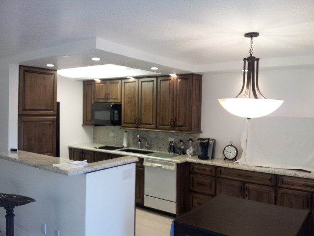 Inspiration for a mid-sized transitional galley eat-in kitchen remodel in Miami with raised-panel cabinets, dark wood cabinets, granite countertops, multicolored backsplash, stone slab backsplash, white appliances and no island