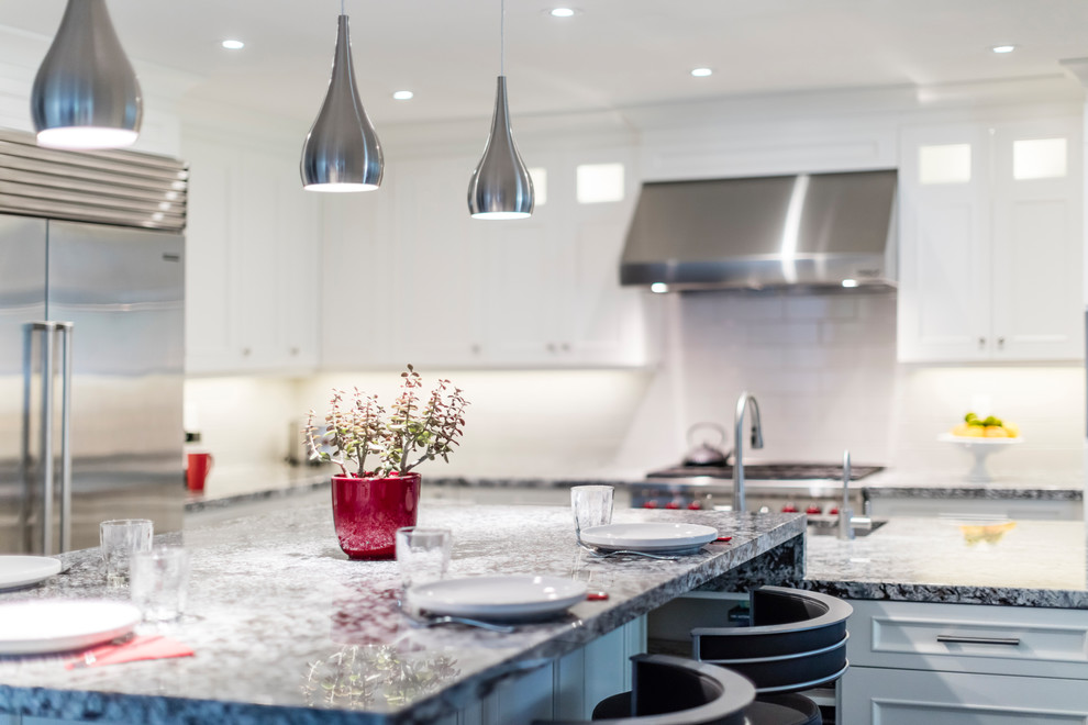 Mid-sized transitional brown floor kitchen photo in Toronto with white cabinets, stainless steel appliances and an island
