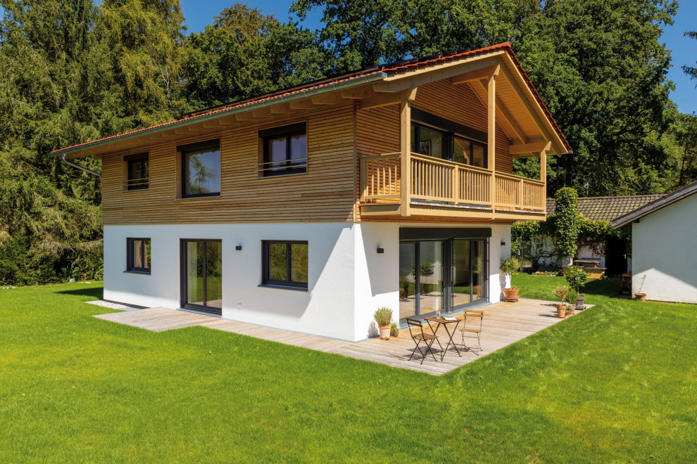 Idée de décoration pour une façade de maison marron champêtre en bois et bardage à clin de taille moyenne et à un étage avec un toit en tuile.