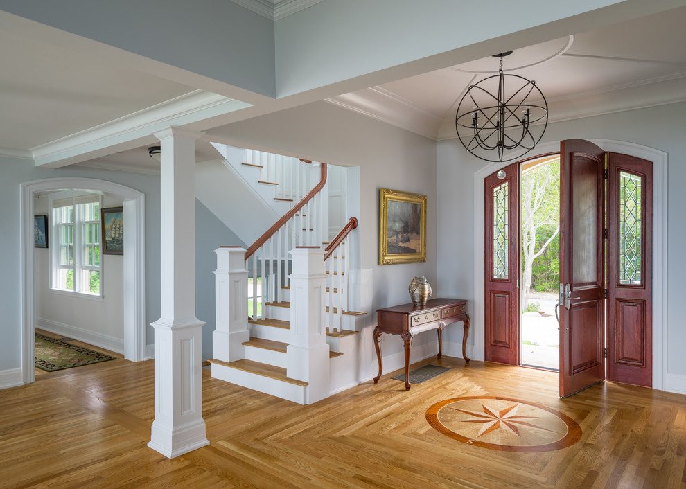 Design ideas for a large traditional foyer in Boston with blue walls, light hardwood floors, a single front door and a dark wood front door.