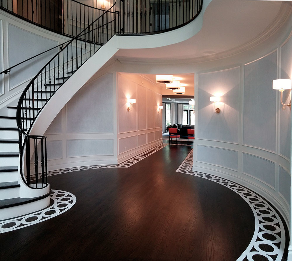 Photo of a large transitional foyer in New York with white walls and painted wood floors.