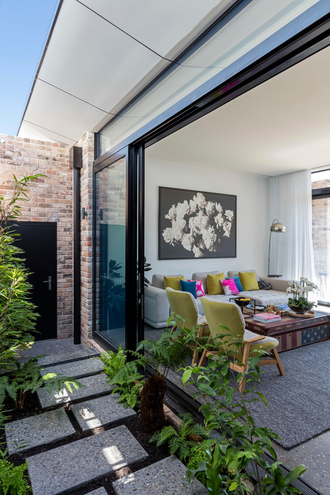This is an example of a mid-sized contemporary open concept living room in Wollongong with white walls, concrete floors, a concrete fireplace surround and no tv.