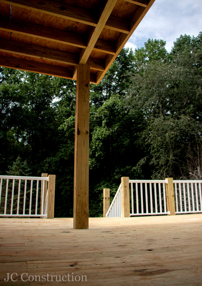 Country backyard metal railing deck photo in Other with an awning