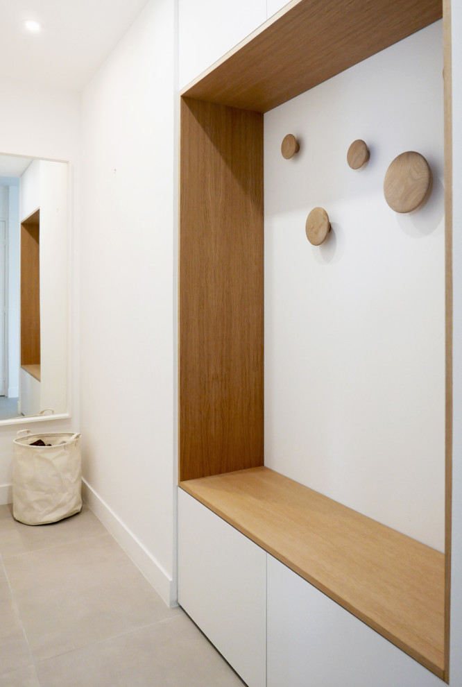 Réalisation d'une grande armoire encastrée design en bois clair avec un placard à porte affleurante, sol en béton ciré, un sol gris et un plafond décaissé.