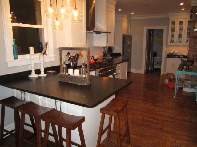 Example of a mid-sized galley dark wood floor enclosed kitchen design in Chicago with shaker cabinets, white cabinets, granite countertops, white backsplash, stainless steel appliances and a peninsula
