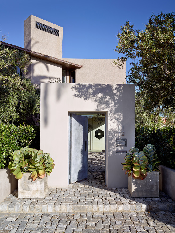 Design ideas for a mediterranean front door in San Diego with beige walls, a single front door, granite floors and a metal front door.