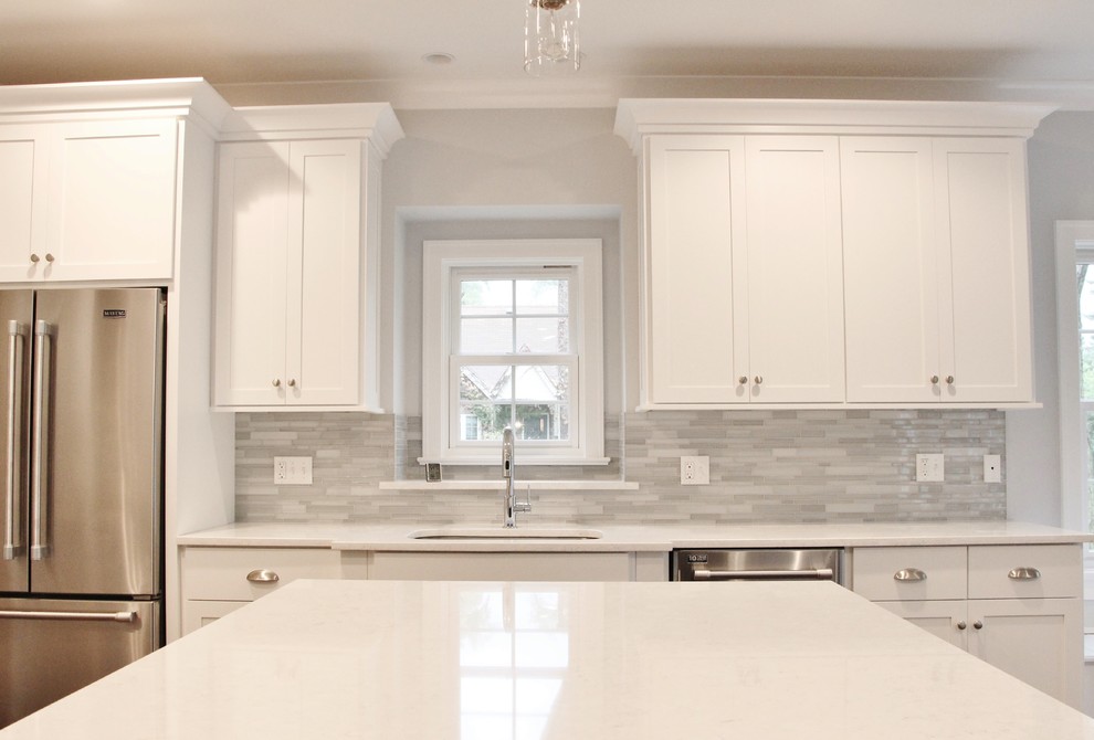 Large transitional l-shaped dark wood floor eat-in kitchen photo in Chicago with a double-bowl sink, shaker cabinets, white cabinets, marble countertops, gray backsplash, glass tile backsplash, stainless steel appliances and an island