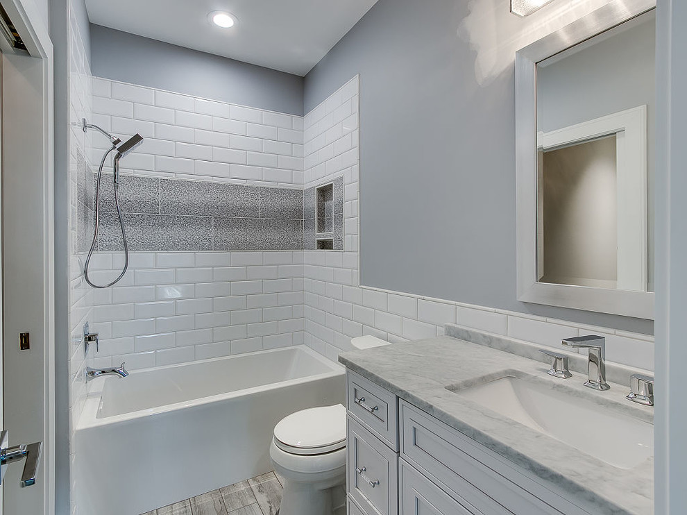 Alcove bathtub - transitional kids' alcove bathtub idea with flat-panel cabinets, white cabinets, a two-piece toilet, gray walls and an undermount sink