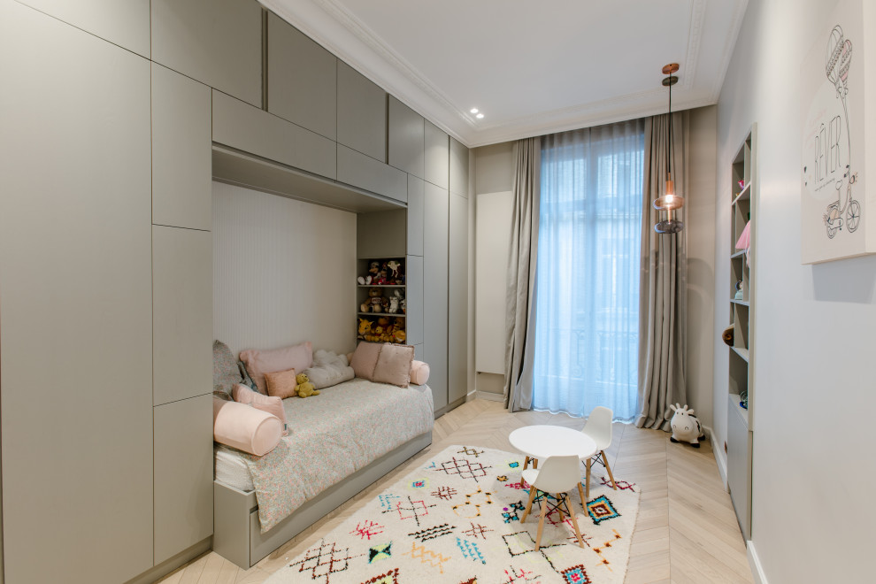 Inspiration for a contemporary kids' room for girls in Paris with grey walls and light hardwood floors.