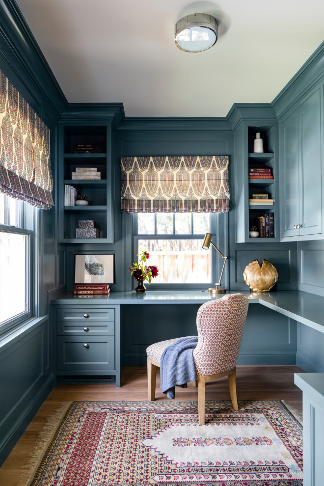 Example of a classic built-in desk medium tone wood floor, brown floor and wainscoting study room design in San Francisco with blue walls