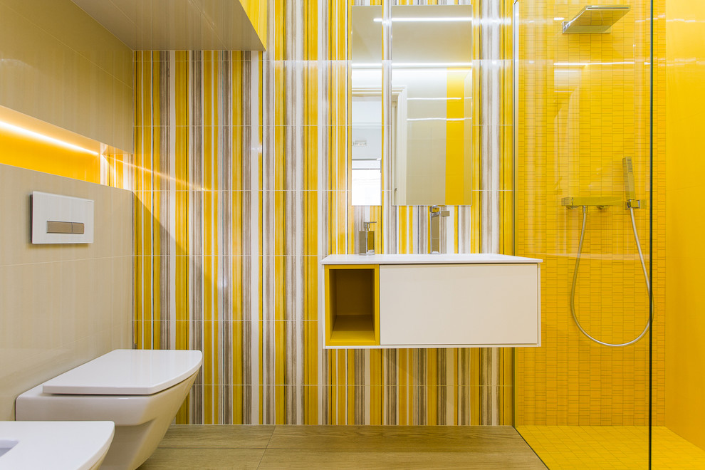 Photo of a mid-sized modern 3/4 bathroom in Barcelona with flat-panel cabinets, white cabinets, a curbless shower, a wall-mount toilet, yellow walls, medium hardwood floors and an integrated sink.