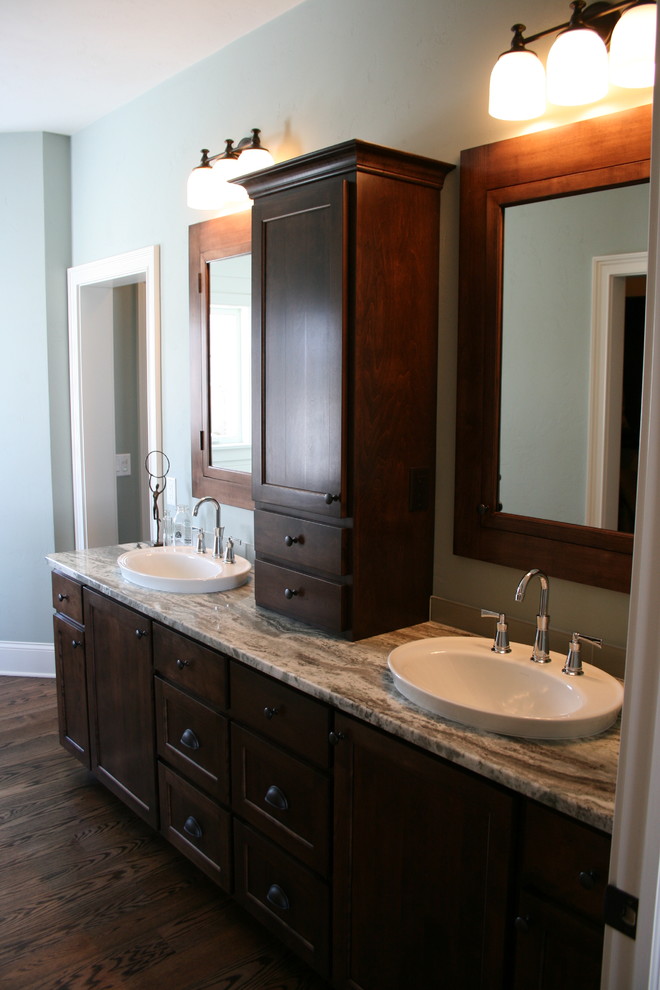 Example of a mid-sized transitional master dark wood floor freestanding bathtub design with a drop-in sink, shaker cabinets, dark wood cabinets, granite countertops, blue walls and a two-piece toilet