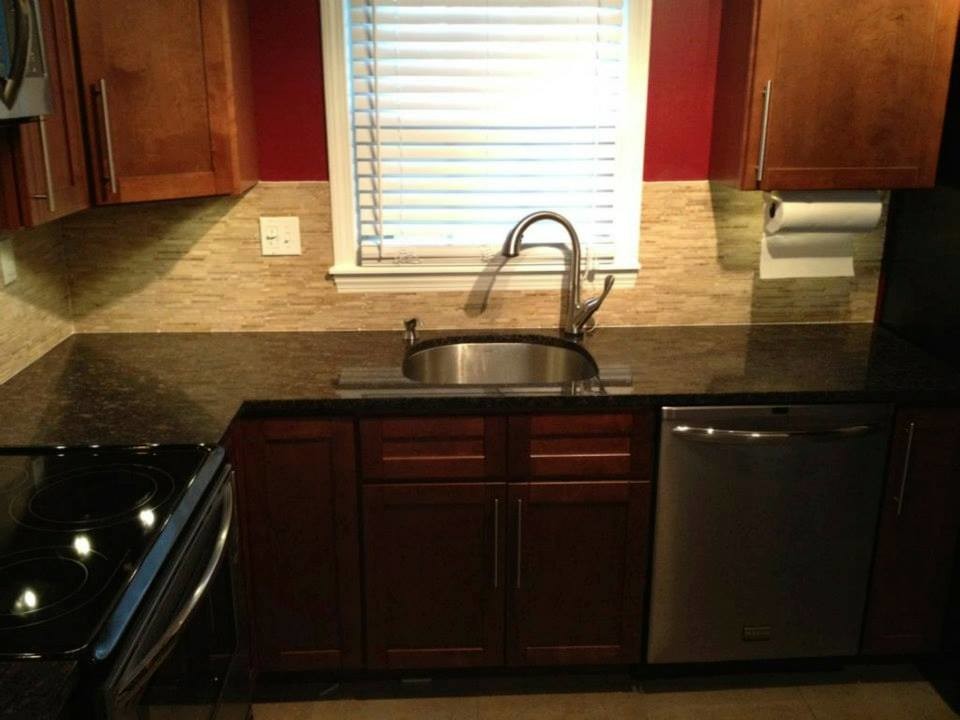 Inspiration for a l-shaped open concept kitchen remodel with an integrated sink, recessed-panel cabinets, medium tone wood cabinets, multicolored backsplash, matchstick tile backsplash and stainless steel appliances