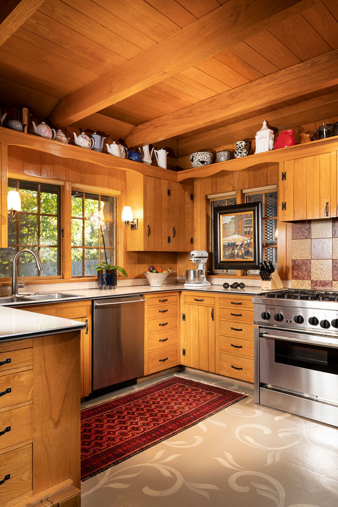 Photo of a country u-shaped kitchen in Other with a double-bowl sink, flat-panel cabinets, medium wood cabinets, stainless steel appliances, a peninsula, grey floor and white benchtop.