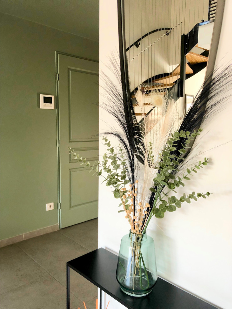 Mid-sized contemporary front door in Lyon with green walls, ceramic floors, a light wood front door and grey floor.