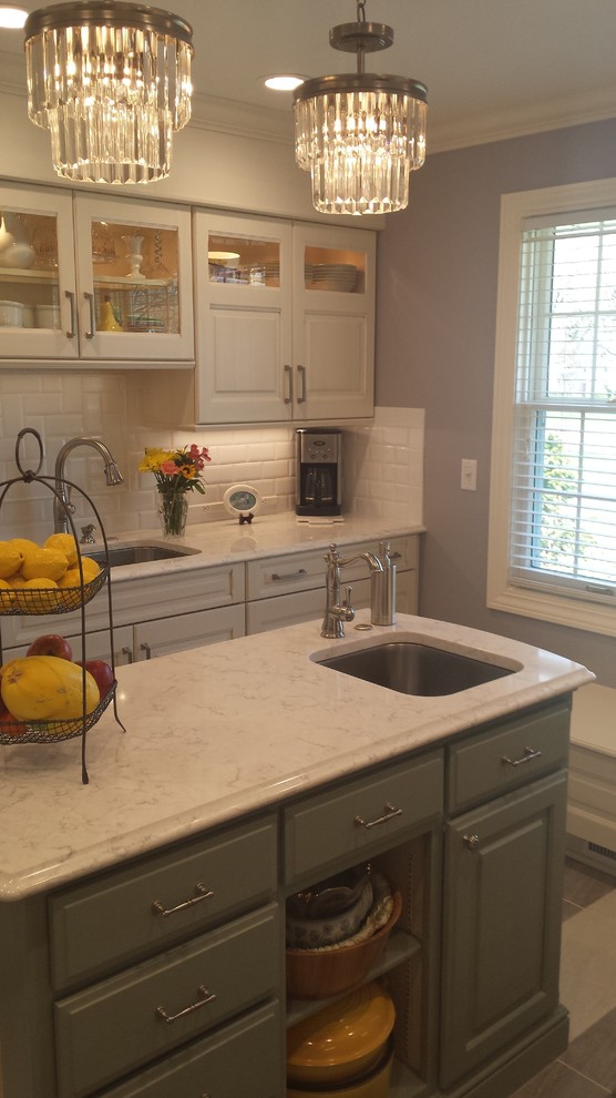 Example of a small transitional u-shaped ceramic tile eat-in kitchen design with a double-bowl sink, raised-panel cabinets, white cabinets, marble countertops, white backsplash, subway tile backsplash, stainless steel appliances and an island