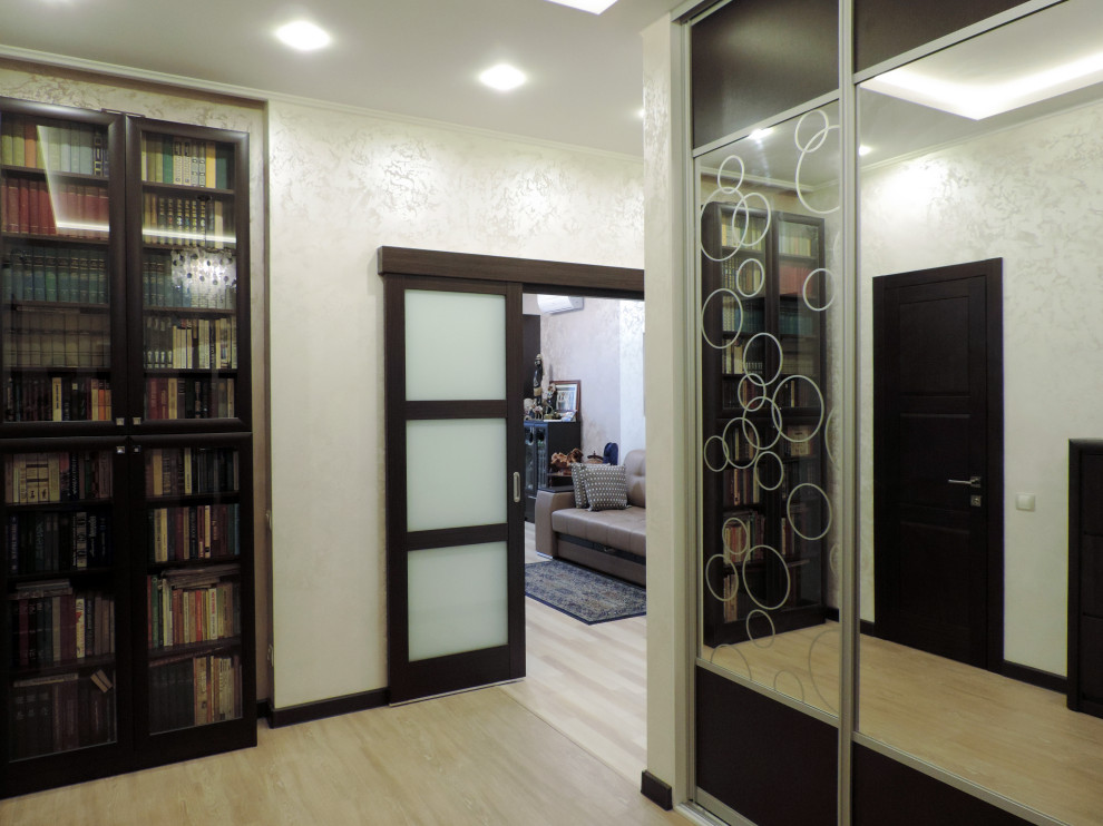 Photo of a mid-sized transitional vestibule in Moscow with beige walls, laminate floors, a single front door, a brown front door, beige floor and recessed.